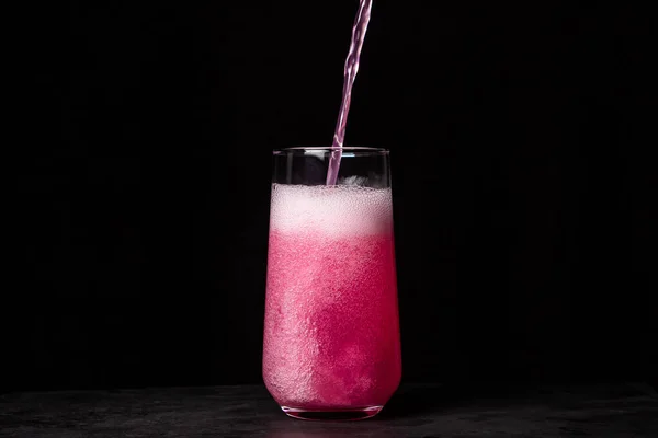 Roze Drank Wordt Een Zwarte Achtergrond Een Glas Gegoten Koolzuurhoudend — Stockfoto