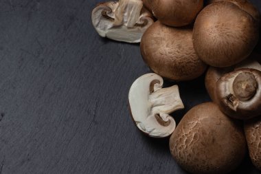 Siyah arka planda kahverengi şampiyonlar. Şampiyon ikiye bölündü. taze mantarlar