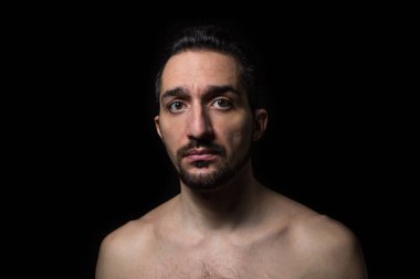 Üzücü bir ifade. Siyah bir arka planda erkek portresi. Umutsuz durum