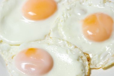 Yakın plan çırpılmış yumurta. Bir tabakta üç yumurta. Hızlı ve lezzetli bir kahvaltı.