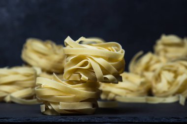 Siyah arka planda makarna yuvaları. Makarna şekli. Geleneksel yemek