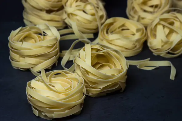 Pasta Nestelt Een Zwarte Achtergrond Vorm Van Pasta Traditionele Keuken — Stockfoto