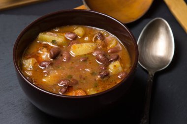 Siyah arka planda tabakta etli fasulye çorbası. Geleneksel yemek. Lezzetli ve besleyici bir yemek.