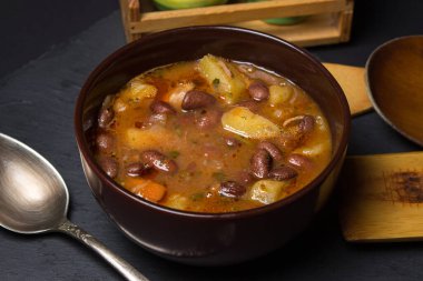 Siyah arka planda tabakta etli fasulye çorbası. Geleneksel yemek. Lezzetli ve besleyici bir yemek.