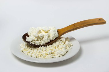 Beyaz arka planda bir tabak süzme peynir. Sağlıklı ve lezzetli süt ürünleri.