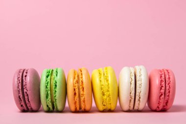 Pembe arka planda renkli badem kurabiyeleri. Hafif ve lezzetli bir tatlı. geleneksel tatlı