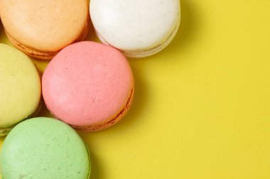 Sarı arka planda renkli badem kurabiyeleri. Hafif ve lezzetli bir tatlı. geleneksel tatlı