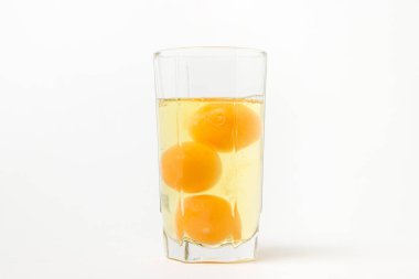Beyaz arka planda kırık çiğ tavuk yumurtası. Tavuk yumurtası sarısı. Çiğ tavuk yumurtası içiyorum.