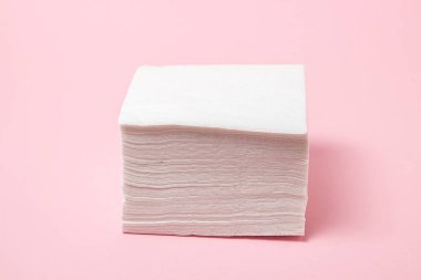 Pembe arka planda beyaz masa peçeteleri. Temizlikçi. kağıt peçeteler