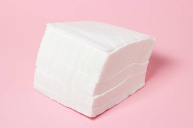 Pembe arka planda beyaz masa peçeteleri. Temizlikçi. kağıt peçeteler