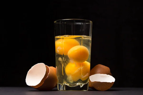 배경의 유리잔에서 계란을 닭고기 노른자 달걀을 마시는 — 스톡 사진