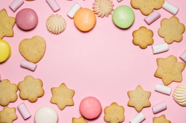 Pembe arka planda tatlılar. Bir sürü farklı tatlı. Kopyalama alanı var.