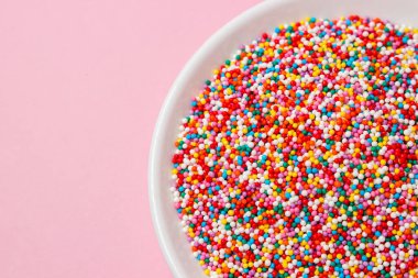 Pembe arka planda şekerleme malzemesi. Tatlı ve hamur işleri için zirvede. küçük karamel topları