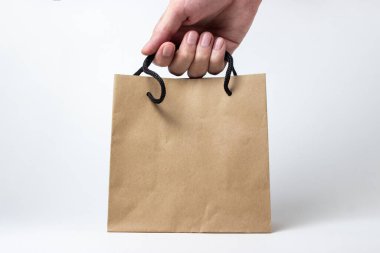 Bir el beyaz arka planda bir kese kağıdı alır. Alışveriş konsepti. Çevre dostu kese kağıdı.