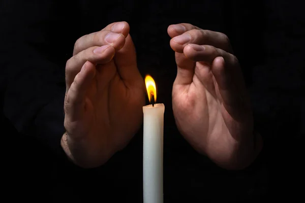 Hände Neben Einer Brennenden Kerze Auf Schwarzem Hintergrund Eine Brennende — Stockfoto