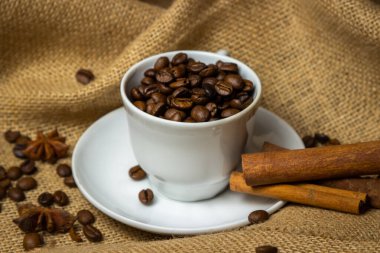 Kahve fincanı kahve çekirdeği dolu. Çuval bezeli kahve çekirdekleri..