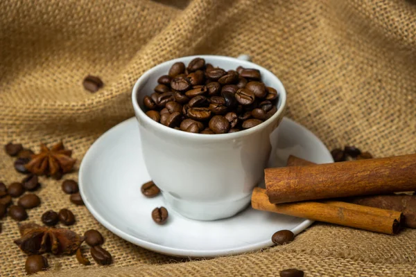 Kahve fincanı kahve çekirdeği dolu. Çuval bezeli kahve çekirdekleri..