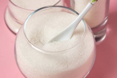 Pembe arka planda şeker. Farklı cam kaplarda şeker. Şeker rezervleri