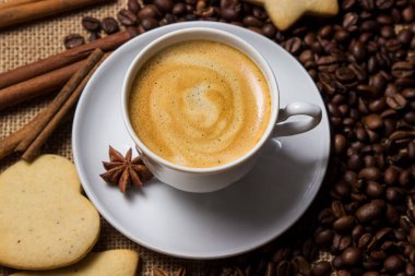 Kahve çekirdeğinin arka planında Espresso kahvesi. Tarçınlı bir fincan kahve. Canlandırıcı içecek.