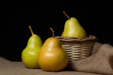 Siyah arka planda armutlar. Olgun sarı armutlar. Sulu ve taze meyveler