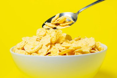 Sarı arka planda mısır gevreği. Faydalı ve lezzetli bir kahvaltı. Diyet yemek.