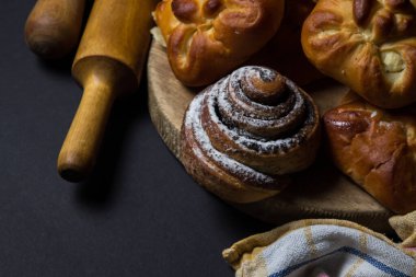 Siyah arka planda çörekler. Bir demet ev yapımı çörek. Lezzetli kahvaltı.