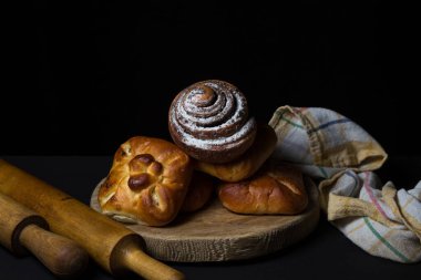 Siyah arka planda çörekler. Bir demet ev yapımı çörek. Lezzetli kahvaltı.