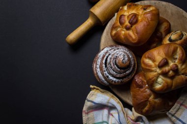 Siyah arka planda çörekler. Bir demet ev yapımı çörek. Lezzetli kahvaltı.