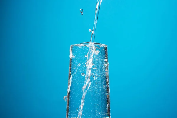 Vatten Hälls Ett Glas Blå Bakgrund Rent Dricksvatten — Stockfoto