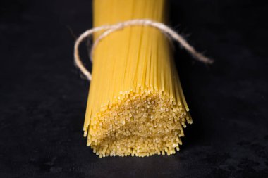 Siyah arka planda kuru spagetti. Geleneksel İtalyan yemekleri. Makarna