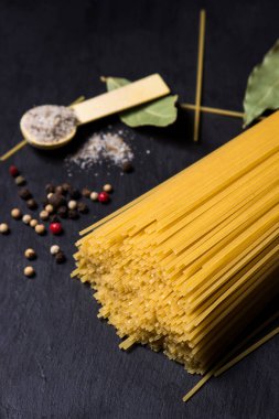 Siyah arka planda kuru spagetti. Geleneksel İtalyan yemekleri. Makarna