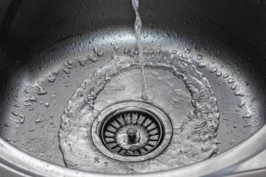 Mutfak lavabosuna su dökülüyor. Bulaşıkları yıkıyorum. ev tesisatı