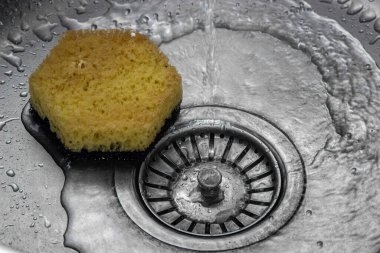 Mutfak lavabosuna su dökülüyor. Bulaşıkları yıkıyorum. ev tesisatı