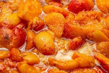 Kayısı reçeli hazırlığı. Şerbetli kayısı parçacıkları. Tatlı meyve tatlısı