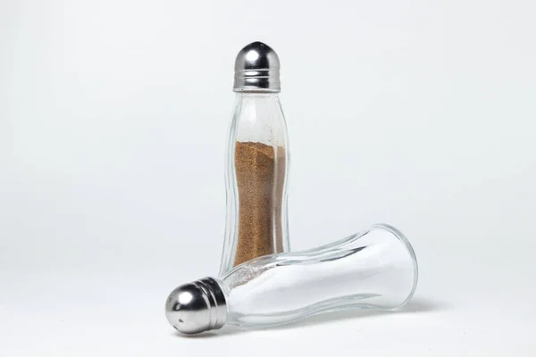 Salt and pepper shaker on a white background. Glass transparent salt shakers