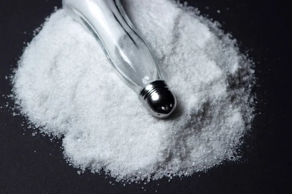 黒い背景に塩の山に塩のシェーカー 過剰な塩分摂取 — ストック写真