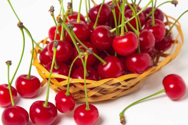 Beyaz arka planda bir sepetin içindeki kiraz. Taze kiraz. yaz meyvesi