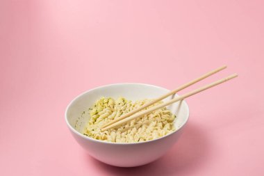 Pembe arka planda haşlanmış hazır şehriye. Fast food. Modern yemek..