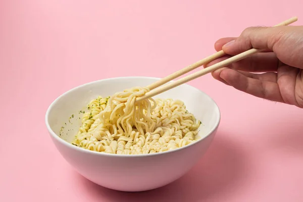 Macarrão Instantâneo Cozido Fundo Rosa Mão Leva Macarrão Com Pauzinhos — Fotografia de Stock