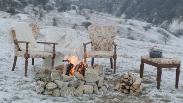 Ogień na śniegu z wygodnymi fotelami i puszystymi łóżkami dla pięknej pary. — Wideo stockowe