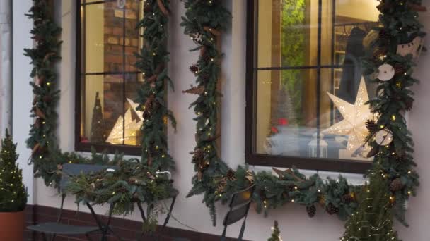 Windows decorated to Christmas with christmas trees fir branches, decorations and garland lights — Stock Video