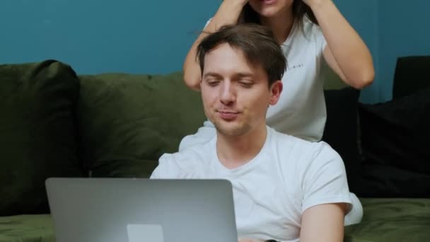 Young man that is working at the computer while his wife are kissing him — Stock Video