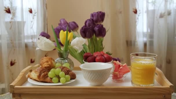 Zamknij Tacę Sokiem Pomarańczowym Croissant Owoców Kwiaty Przygotowane Śniadanie Łóżku — Wideo stockowe