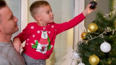 sevimli oğlu babasının oturma odasında ile Noel ağacı süsleme