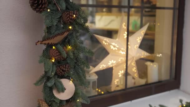 Ramen versierd met kerstbomen dennen takken, decoraties en bloemenslinger lichten — Stockvideo