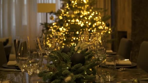 Mesa de Navidad tradicionalmente decorada con un árbol de Navidad en el fondo. — Vídeos de Stock