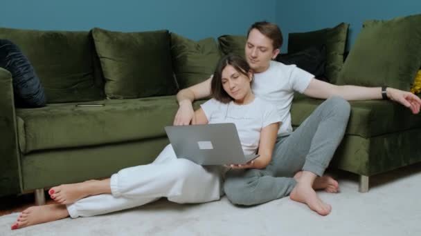 Kvinna som arbetar vid datorn får en bukett gula tulpaner från sin man. — Stockvideo