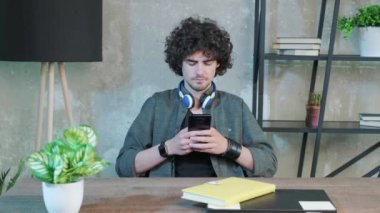 Ciddi bir genç adam evinde oturuyor ve arkadaşlarına mesaj atıyor..