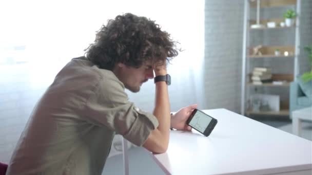 Zaměřte se na telefon, Mladý muž zklamán z neúspěšné strategie obchodování — Stock video