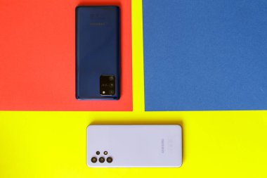 Zaporozhye Ukrayna - 12 Ağustos 2021: Samsung gökadası S 10 lite ve Samsung gökadası A32 kırmızı ve sarı arka planda izole edilmiştir. Üst arka görünüm.